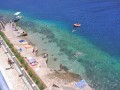 Chorwacja to kraj od lat wybierany jako miejsce wakacji przez turystów z całego świata. Piękne krajobrazy, historyczne zabytki, doskonała kuchnia i wspaniałe plaże to prawdziwy magnez na turystów. Miejscem szczególnie odwiedzanym jest Korcula (Korčula), czyli wyspa położona w Dalmacji. To właśnie z niej, według legend, wywodzi się znany podróżnik i odkrywca, Marco Polo. To miejsce idealnie nadające się na wypoczynek w pięknej scenerii przy kieliszku wybornego wina. Dla wszystkich, którzy chcą uciec od zgiełku i hałasu, szczególnie polecana jest Brna, czyli zatoka położona w południowej części Korculi. Cicha i spokojna, jednak w dogodny sposób połączona z okolicznymi miejscowościami to idealne miejsce na urlop.


Historia


Region, w którym znajduje się Brna słynie z doskonałych winnic, które rozwijają się na tutejszych terenach od wieków. Jako że właśnie z okolic Brni, pochodzą najsłynniejsze chorwackie wina, takie jak chociażby Rukatac, dlatego też wioska Brna powstała w XIX wieku jak port załadunkowy. Głównym ośrodkiem produkcji win była pobliska Smokvica, dlatego zatoka Brna, oddalona zaledwie o 4 km była idealnym miejscem na zorganizowanie w niej portu. Obecnie, zarówno wioska jak i cała zatoka Brna, służy celem turystycznym jednak da się tutaj wyczuć powiew dawnych czasów.


Atrakcje turystyczne


Brna to miejscowość, która jest doskonałą bazą wypadową do okolicznych miasteczek. Warto udać się do oddalonej o 4 km Smokvicy, aby zobaczyć na własne oczy miejsce, gdzie produkowane jest słynne w całej Chorwacji, wino Pošip. Zwolennicy budowli z przeszłości, podczas spaceru po miasteczku, będą mieli okazję zobaczyć kilka średniowiecznych kościółków, czy rezydencje możnych sprzed kilku wieków. Niezwykle ciekawym wydarzeniem będzie pokaz Kumpaniji. Ten dawny taniec rycerski, to niezwykle widowiskowy spektakl, podczas którego mężczyźni, w tradycyjnych rycerskich strojach, odgrywają za pomocą tańca, scenę walki. Efektowne flagi i wielkie miecze, nadają całemu wydarzeniu dodatkowej atrakcyjności. Kierując się w drugą stronę od Brni, można udać się do miejscowości Istruga, która słynie z leczniczych błot, doskonale wpływających zwłaszcza na choroby reumatyczne.


Plaże i sporty


W samej Brni, plaża składa się ze skałek. Mimo to, spokojnie można tam zażywać kąpieli słonecznych i nie tylko. Wejście do wody jest ułatwione za pomocą drabinek, które pozwalają dostać się do krystalicznie czystej wody. Okolice plaży w Brni są idealne do nurkowania. To także miejsce idealne dla miłośników żeglarstwa. Jeśli jesteś zwolennikiem plaż piaszczystych, musisz udać się do pobliskiej Istrugi. Znajduje się tutaj nie tylko piaszczysta plaża, ale również całe centrum sportowo - rekreacyjne, gdzie można uprawiać takie sporty jak chociażby tenis, siatkówka czy tenis stołowy. Znajdziesz tutaj także plac zabaw dla dzieci, kilka sklepów i restauracji.


Noclegi


W Brni baza noclegowa rozwija się coraz lepiej. Ceny za noclegi zależą od standardu jakiego poszukujesz. Do wyboru są zarówno apartamenty, kwatery prywatne u gościnnych Chorwatów, jak również hotel. Zważywszy na rozwój turystyczny tej miejscowości, niewykluczone że już wkrótce na jej terenie pojawią się kolejne hotele czy pensjonaty, dzięki czemu jeszcze większa ilość turystów będzie mogła odpoczywać w tej urokliwej miejscowości.


Wycieczki


Będąc na wakacjach w Brni warto udać się do stolicy wyspy. Mowa o mieście Korcula, oddalonym zaledwie o 34 km od Brni. To piękne miasto zachęca do spacerów po zabytkowych uliczkach. Ciekawostką jest natomiasta fakt, że każda z nich kończy się schodami. W ten sposób Korcula przypomina labirynt. Uroku miastu dodają również stare mury obronne a także muzeum poświęcone najznakomitszemu mieszkańcowi Korculi, czyli podróżnikowi Marco Polo. Będąc w tym mieście koniecznie należy zobaczyć Moreskę czyli grę rycersko- ludową, którą obecnie można zobaczyć tylko tutaj. To niezwykle dynamiczne widowisko, składające się z 7 żywiołowych tańców, porywającej muzyki oraz pięknych strojów, to coś czego nie można przegapić. Będąc w Brni można także udać się na wycieczkę do oddalonej o 20 km Velej Luki. Zwolennicy archeologii mogą zwiedzić tutejsze centrum kultury, w którym znajdują się zbiory z czasów neolitycznych oraz rzymskich.


Kuchnia


Jako miejscowość portowa, Brna słynie ze swoich ryb. Można udać się do restauracji aby skosztować specjałów z grilla, ale równie dobrze można zakupić świeże ryby u handlarza na ulicy. Od ulicznych sprzedawców warto także kupować owoce, których smak jest zdecydowanie lepszy od tych sprzedawanych w supermarketach. Obowiązkowo należy skosztować któregoś z najsłynniejszych win, czyli Pošip lub Rukatac.


Klimat


Tutejszy klimat charakteryzuje 2700 słonecznych godzin rocznie. Roczna, średnia temperatura oscyluje w granicach 17°C. W okresie letnim średnie temperatury wynoszą około 27°C, a zimą w graniach 10°C. Jeśli dodamy do tego ciepły i czysty Adriatyk, wiadomo już dlaczego turyści upodobali sobie te rejony.