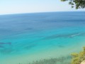 Złote plaże, luksusowe hotele nad brzegiem Morza Egejskiego, surfingowe szaleństwo - wszystko to znajdziecie w Sani - uroczym kurorcie położonym w północnej Grecji, a konkretniej w skąpanym w słońcu rejonie Chalkidiki, na Półwyspie Kasandra (Pallene), około 100 kilometrów od Salonik. Ta niewielka niegdyś osada rybacka szybko zamieniła się w prawdziwy raj dla turystów. Sani to miejsce ekskluzywne, malownicze i w odróżnieniu od większości kurortów położonych na Kasandrze - spokojne. Idealne wakacje spędzą tu wszyscy, którzy pragną wypocząć w otoczeniu pięknych krajobrazów, będąc jednocześnie zaledwie o krok od tętniących życiem barów, klubów i dyskotek. 


Historia


Półwysep Chalcydycki jest jednym z najstarszych w Europie. To tutaj urodził się Arystoteles, a rejon uznawany jest za kolebkę hellenistycznej kultury i europejskiej cywilizacji.
 
Historia samego miasteczka Sani sięga VIII wieku p.n.e., jednak jego początków możemy doszukiwać się już w mitologii greckiej. Dawniej wierzono, że Półwysep Kasandra - którego pierwotna nazwa brzmi Phlegra (miejsce ognia) był domem gigantów. Legenda głosi, że jeden z olbrzymów został trącony przez boga skałą, a podczas bitwy bogów z gigantami, giganci próbowali rzucić we władców Olimpu wznoszącymi się na Kasandrze górami Athos! Bogowie jednak wygrali bitwę, a przegrany przywódca gigantów - Enceladus miał zostać pochowany żywcem na półwyspie Kasandra. To podobno właśnie Enceladus powoduje tutejsze trzęsienia ziemi, gdyż - wierząc mitologii - próbuje wydostać się z grobu. Co ciekawe, najwcześniejsze zapiski o historycznych Chalkidikach pochodzą z czasów króla Heroda. Kroniki opisują straszliwą burzę właśnie nad górami Athos, która doszczętnie zniszczyła flotę Mardoniusza.
 
W przeszłości Chalkidiki były nie tylko pod władaniem greckim, ale również rzymskim, macedońskim, perskim, weneckim i tureckim - z którego zostały wyzwolone dopiero w 1912 roku stając się częścią greckiej Macedonii. Zupełnie nową kartę w historii regionu otwiera rok 1922, kiedy to tysiące uchodźców z Azji Mniejszej, Bułgarii i historycznej Tracji zaczęło osiedlać się na ziemiach Półwyspu Chalcydyckiego. Dziś Chalkidiki to rejon głównie turystyczny, w którym o dawnych bitwach i bujnej przeszłości przypominają jedynie zabytki.


Atrakcje turystyczne


Wszystkim wczasowiczom polecamy piesze wycieczki po Sani i jego najbliższych okolicach. Niezwykle malowniczy półwysep Kasandra to raj dla piechurów, miłośników przyrody oraz wszystkich tych, którzy lubią wypoczywać w otoczeniu bujnej zieleni, szumu rozbijających się o brzeg fal, wśród śpiewu ptaków. Nie bądźcie zdziwieni, gdy podczas spaceru spotkacie królika, czy żółwia. Rejon jest bogaty w skarby natury, których na próżno szukać w pozostałych częściach Chalkidików. Maszerując przez dolinę Koutsoupi będziecie mieli okazję nie tylko zobaczyć niezwykle rzadkie gatunki roślin. Pośród dębowych drzew znajdują się ruiny rzymskich willi oraz wczesnochrześcijańskiej świątyni, a także rezerwat wodno-błotnych ptaków.

Ponadto od 1993 roku organizowany jest tutaj regularnie Sani Festiwal, który jest charakterystyczną i osobliwą, międzynarodową imprezą regionu. Organizowany jest on każdego lata, pod gołym niebem, a na scenie dawnego amfiteatru (pięknie ozdobionego średniowieczną wieżą oraz widokiem na skaliste wybrzeże) pojawiają się muzycy i artyści prezentujący najróżniejsze utwory - od jazzowych, przez folkowe, a na muzyce popularnej kończąc. W ubiegłym roku, turystów jak magnez przyciągnął festiwal „Jazz on the Hill”, który gościł najlepszych muzyków z całego świata - m.in. z Korei i Szwecji. Wczasowicze świetnie bawili się na wieczornych koncertach uwielbianego za oceanem Jana Lundgrena, czy pięknej Victorii Tołstoj (tak, to pra pra wnuczka słynnego pisarza Lwa Tołstoja!). Koncerty, przeróżnych artystów w sezonie odbywają się praktycznie co weekend. Wstęp na niektóre imprezy jest bezpłatny, za inne trzeba zapłacić od 6 do 30 euro.

Inną, godną uwagi atrakcją jest wycieczka do kanału Nea Pontidea przecinającego półwysep, gdzie można podziwiać ruiny dawnych fortyfikacji, a także nieźle się zabawić. Tamtejsza promenada pełna jest barów i tętniących życiem klubów. W niewielkiej miejscowości Kriopagi godną uwagi jest cerkiew św. Dymitriusza położona w gaju oliwnym.
 
Zmęczonym po pełnym wrażeń dniu turystom polecamy romantyczny rejs statkiem o zachodzie słońca, czy wieczór w kinie na świeżym powietrzu.
 
 
Noclegi i plaże
 
 
Półwysep Kasandra to chyba najbardziej ukochany przez turystów rejon w Chalkidikach. Dlaczego? To właśnie tutaj znajduje się najbardziej rozbudowana baza turystyczna, zlokalizowanych jest najwięcej hoteli oraz wszelkiego rodzaju udogodnień dla spragnionych wypoczynku wczasowiczów.

Urlop w Sani to z pewnością wakacje z wyższej półki. Większość hoteli to pięcio i czterogwiazdkowe resorty, oferujące swoim gościom cały szereg rozmaitych atrakcji, poczynając od basenów (w jednym z hoteli istnieje nawet możliwość wynajęcia apartamentu suit z prywatnym basenem), tarasów, oferty menu all inclusive, poprzez liczne udogodnienia sportowe (boiska do siatkówki, koszykówki, oświetlone korty tenisowe), a na saunach i ośrodkach spa & wellness kończąc.

Dla letników, którzy nie przepadają za pławieniem się w luksusach polecamy noclegi na pobliskich campingach, przy czym należy pamiętać, że na całym półwyspie obowiązuje bezwzględny zakaz tzw. „obozowania na dziko”. Jeśli jednak planujemy urlop w szczycie sezonu (druga połowa lipca, pierwsza połowa sierpnia) nie zapomnijmy o wcześniejszej rezerwacji miejsca - tym sposobem unikniemy przykrych niespodzianek. 
Plaże to jeden z głównych atutów wypoczynku w okolicach Sani. Zdecydowana większość z nich to przyjemne białe plaże piaszczyste. Niemal każde kąpielisko wyposażone jest w bezpłatne prysznice. W poszczególnych tygodniach lata podczas pływania należy uważać na meduzy - są one niegroźne, jednak warto być uprzedzonym o ich ewentualnej obecności w wodzie - zwłaszcza, jeśli wypoczywamy z dziećmi.

Niewątpliwą zaletą kąpielisk w Sani jest także niemalże nieograniczona możliwość uprawiania sportów wodnych. Na miejscu znajdziemy wypożyczalnię sprzętu oraz wykwalifikowaną kadrę instruktorów, którzy pomogą nam wypłynąć na szerokie wody. Nurkowanie, kajakarstwo, żeglarstwo, windsurfing i wiele, wiele innych - wszystko to, czeka na Was w tym niewielkim, greckim miasteczku.


Wycieczki fakultatywne


Na spragnionych wrażeń urlopowiczów w Sani i okolicach czeka moc atrakcji. Jedną z godnych polecenia wycieczek jest wyprawa do malowniczej Arnei - stolicy chalcydyckiego wina. Zwiedzanie okolicznych winiarni można połączyć z wypadem do położnych nieopodal Salonik.
 
W niedalekim sąsiedztwie kurortu położone są miejscowości takie jak słynąca z zabytków sakralnych Furka, tętniąca życiem Kallithea, znana z malowniczych plaż Kalandra (gdzie można również obejrzeć ruiny starożytnego miasta Mendli) oraz szczycące się zjawiskową architekturą, zabytkowe miasteczko Afitos. Zaledwie 14 minut drogi dzieli Sani od Kassandrii - największego miasta półwyspu, gdzie znajdziemy nie tylko całe mnóstwo godnych polecania greckich restauracji, ale również uroczą starówkę.

Przejeżdżając przez południową część półwyspu Kasandra warto zatrzymać się w okolicach miasteczka Paliouri. Ta górska wioska słynie przede wszystkim z imponującej kolekcji antycznych rzeźb oraz z ciekawych elementów architektonicznych. Przy okazji można zobaczyć znajdujące się w pobliżu ruiny wieży Thermavos.
 
Nieco bliżej Salonik położona jest Nea Moudania - miasto godne uwagi głównie ze względu na tamtejsze Muzeum Morskie, w którym można podziwiać m.in. ciekawą konstrukcję statku rybackiego, a także obejrzeć kilka interesujących filmów dokumentalnych.
 
W zachodniej części regionu obowiązkowym punktem wycieczki na mapie każdego turysty są malownicze wioski Nea Sikoni i Posidi. W pierwszej z nich godnymi podziwu są nie tylko przepiękne widoki, ale także ruiny starej wioski Tsaprani oraz kościółek Panagia Faneromeni z godnymi uwagi malowidłami ściennymi. Natomiast Posidi to miejscowość, w pobliżu której odkryto świątynię Posejdona wraz z pozostałościami po kilku grobowcach.

Wymieniając warte odwiedzenia zakątki, grzechem byłoby pominąć malowniczą Sitonię. Dzikie plaże, zapierające dech w piersiach widoki, brukowane uliczki i charakterystyczna architektura - wszystko to sprawia wrażenie, że w Sitonii czas się zatrzymał.

Amatorów przygód z pewnością zaś zainteresują, położone około 30 kilometrów od samego Sani, jaskinie Petralona. Odnaleziono tam m.in. czaszkę neandertalczyka, prehistoryczne narzędzia. Można tam ponadto obejrzeć zadziwiające formy skalne wydrążone przez krążącą w wapieniach wodę.

W pamięci zapadnie nam również wycieczka do klasztorów położonych na świętej górze Athos, do których dopłynąć można łodzią. Jest to jednak wycieczka przeznaczona jedynie dla mężczyzn - kobiety nie mają wstępu ani do klasztorów, ani na tereny je otaczające. Podczas tej wyprawy podziwiać można tzw. Ogrody Maryi oraz unikalne budowle, których zjawiskowość porównywana jest do klasztorów mnichów tybetańskich. Przewodnika warto podpytać o liczne legendy, które krążą wokół tamtejszych budowli i pamiątek sakralnych. 


Pogoda, klimat, temperatury


Klimat półwyspu Chalcydyckiego określa się jako śródziemnomorski suchy. Latem termometry wskazują około 30-35°C za dnia oraz 20-22°C w nocy. Temperatura wody w szczycie sezonu sięga nawet 25°C. Opady w lipcu, czy sierpniu są rzadkością. Wilgotność powietrza utrzymuje się na poziomie 54-50%. Zimą temperatura nie spada poniżej zera. Najwięcej dni deszczowych przypada na grudzień (12), najmniej na sierpień.