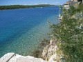 Przeżyć przygodę, zachłysnąć się wyjątkową przyrodą wyspy, dotknąć historii Chorwacji, spędzić wakacje życia - to wszystko w zasięgu ręki. Piaszczyste plaże i cudowny śródziemnomorski klimat, a co godne podkreślenia jedno z najbardziej nasłonecznionych miejsc w Europie. Wyspa Rab należy do najpiękniejszych na Adriatyku. Dużą cześć zajmują urokliwe lasy i pola, a południowo-wschodnie wybrzeże urozmaicone kamiennymi rumowiskami dopełnia wyjątkowy krajobraz. Głównym miastem wyspy jest urokliwy, przyczajony na wybrzeżu Rab. Miasto, w którym historia Chorwacji przeplata się ze wszystkim tym, czego spragniony wypoczynku turysta oczekuje. Liczne apartamenty, kwatery prywatne, hotele, restauracje, puby zapewnią komfortowy wypoczynek, a niezliczone atrakcje, wycieczki, zabytki, piękne plaże dostarczą wrażeń.


Historia


Pierwsze wzmianki o miejscowości Rab pochodzą z 10 roku p.n.e. Początkowo wyspę opanowali Rzymianie. Założyli miasto Arba. Powstały również liczne wille letniskowe i porty. Krótki czas na wyspie panowali Turcy, a następnie Słowianie. Najdłużej (lata 1409 - 1797) to panowanie Wenecjan. Niezbyt tu jednak mile wspominanych, gdyż większość wpływów i dóbr wywożono do Wenecji. Dopiero wiek XIX przyniósł zmiany i Rab przeszedł pod panowanie austriackie. Do dziś język niemiecki przeplata się z chorwackim. Warto wspomnieć, iż to właśnie tu urodził się Marin późniejszy założyciel państwa-miasta San Marino. Bogata historia miasta i wyspy Rab obecna jest na każdym kroku a dla wnikliwych pasjonatów odkrywa coraz to nowe atrakcje.


Zabytki


Dla oka i wrażliwej duszy odkrywcy, wyspa Rab odsłania swe najpiękniejsze perełki architektury, zarówno sakralnej jak i świeckiej. Nie sposób nie wspomnieć o romańskiej katedrze, kościele św. Justyny, klasztorach. Urokliwe mieszczańskie pałacyki, ulica Rade Koncara, mury miejskie wprawiają w zachwyt. Najsłynniejszy zabytek wyspy to cztery wieże kościelne. Liczne uliczki wprost ze średniowiecza, dachy domów pokryte czerwoną dachówką, tarasy z widokiem na Adriatyk. Warte uwagi są ruiny klasztoru Benedyktynów z XI wieku oraz klasztor św. Antoniego. Wspaniałą historię miasta dopełniają odbywające się od roku 1364 turnieje strzelania z kuszy.


Noclegi


Rab to miejsce całorocznego wypoczynku. Każdy turysta znajdzie tu coś dla siebie. Liczne kwatery prywatne, apartamenty, wille, hotele, kampingi oferują noclegi na najwyższym poziomie. Wiele hoteli oferuje usługi All Inclusive. Dynamiczny rozwój turystyki Chorwackiej sprawił, iż oferta jest bardzo bogata i zaspokoi gusta nawet najbardziej wybrednych turystów.


Atrakcje


Rab to niewątpliwie raj dla żeglarzy. Liczne wysepki, sprzyjające wiatry, dwie Mariny, porty jachtowe przyciągają wilki morskie z całego świata. Nierzadko zawijają tu jachty najbogatszych tego świata, a wielu mieszkańców do dziś wspomina czasy, kiedy na wyspie przebywali członkowie brytyjskiej rodziny królewskiej. Liczne parki z niespotykaną roślinnością przyciągają spacerowiczów a dla amatorów mocniejszych wrażeń okalające wyspę Rab wody zachęcają do nurkowania. Warto wybrać się na wycieczkę na najwyższy szczyt wyspy Kamenjak (408m n.p.m.), skąd można podziwiać całe pasmo górskie Velebit. Z dalszych wypadów szczególny polecenia jest Park Narodowy Jezior Plitwickich (Nacjonalni Park Plitvicka Jezera) o powierzchni około 295 km2 słynący z przepięknych jezior i wodospadów. Każdy niewątpliwie znajdzie tu coś dla siebie: 157km tras rowerowych, 144km szlaków turystycznych, 5 centrów nurkowych, korty tenisowe, paintball, seekayak, rybołówstwo, sporty wodne - to tylko najważniejsze atrakcje wyspy. Liczne występy folklorystyczne, festiwal artystyczny (Rapsko Likovno Leto), galerie, popisy zespołów muzycznych z występami „Rab Brass Band” (zespół istniejący nieprzerwanie od 1913 roku!) na czele.


Gastronomia


Gastronomia wyspy Rab ma wielowiekową historię i kultywuje najlepsze tradycje kuchni śródziemnomorskiej jak i chorwackiej. Przysmakami są hodowane ekologicznie na wyspie od ponad ośmiuset lat oliwki, figi i winogrona. Tradycyjne ciasto okraszone miodem niejednego właściciela wyszukanego podniebienia przeniosło do raju. Wspaniałe potrawy z owoców morza. Liczne tawerny, zajazdy, restauracje, puby serwują świeże, zdrowe i smaczne dania.


Perła Chorwacji


Studwudziestoletnia tradycja zorganizowanej turystyki zobowiązuje, ale także jest gwarancją najlepszego wypoczynku. Uprzejmość i wrodzona gościnność mieszkańców wyspy Rab, zielone gaje oliwne, szum morza, piękne plaże, słońce i powiew lekkiej bryzy morskiej zachwyciła już niejednego turystę. Kto raz tu zawitał wraca, a dla wielu słowa: wypoczynek, wakacje, morze, Chorwacja kojarzą się jedynie z wyspą Rab.